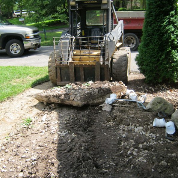 Construction equipment moving earth to make way for hardscape.